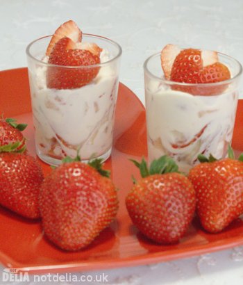 A strawberry and cream dessert in shot glasses on a heart-shaped plate