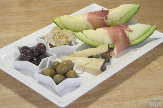 Not Delia's simple Parma ham platter with melon, Manchego cheese, artichoke hearts, and green and kalamata olives